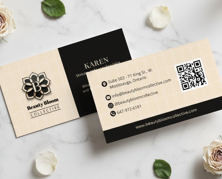 Elegant Beauty Bloom Collective business cards on marble with white roses and green leaves.