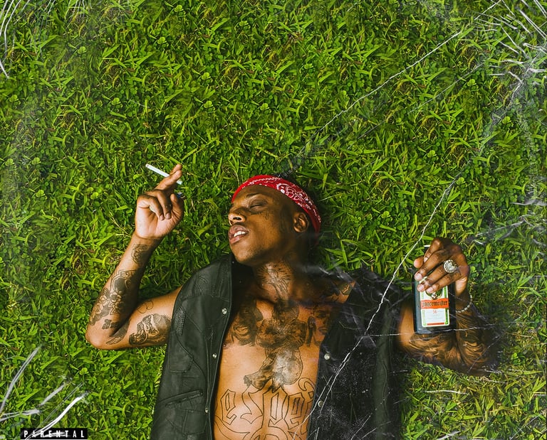 a man with tattoos on his chest and a cigarette