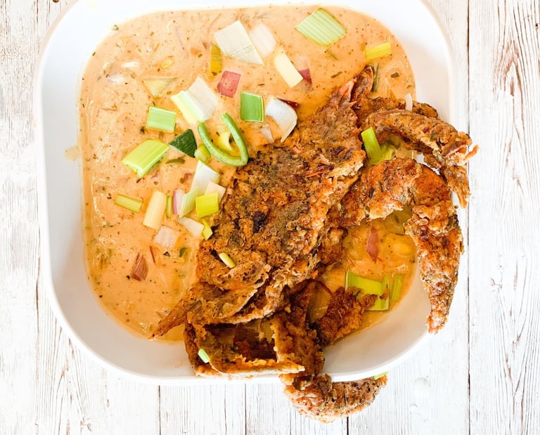 a bowl of soup with a fried crab