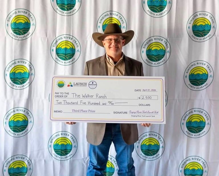 James Walker holding a check after winning The Singing River Trail Launch Tank