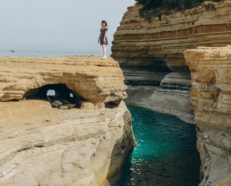 a woman standing on a cliff overlooking the ocean