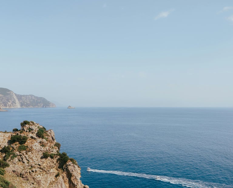 a person standing on a cliff overlooking a body of water