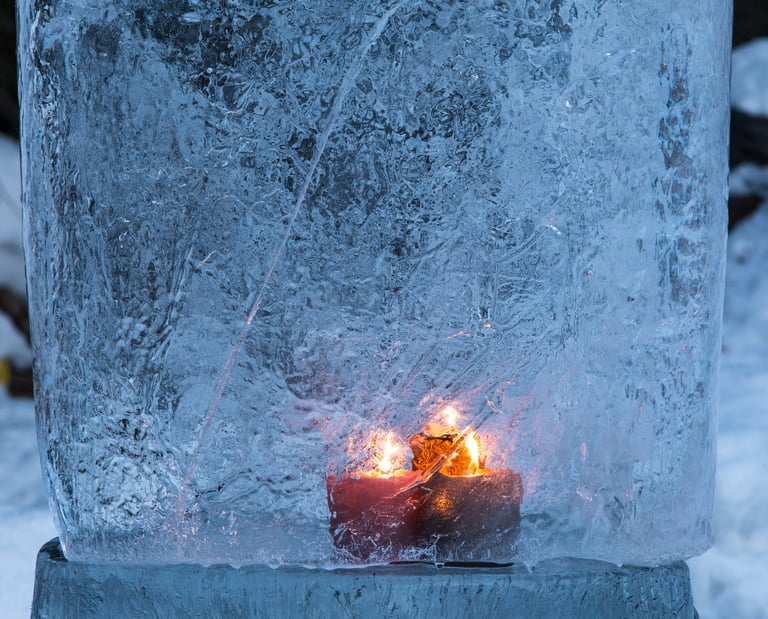 Bougie allumée figée dans la glace, symbole de mémoire et d’introspection hivernale.