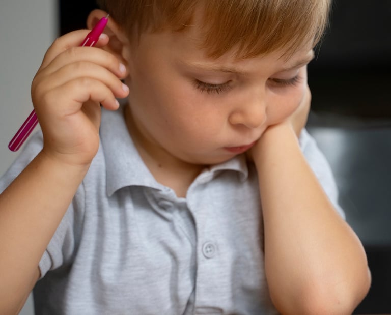 Vaikas susimąstęs bando spręsti užduotį.