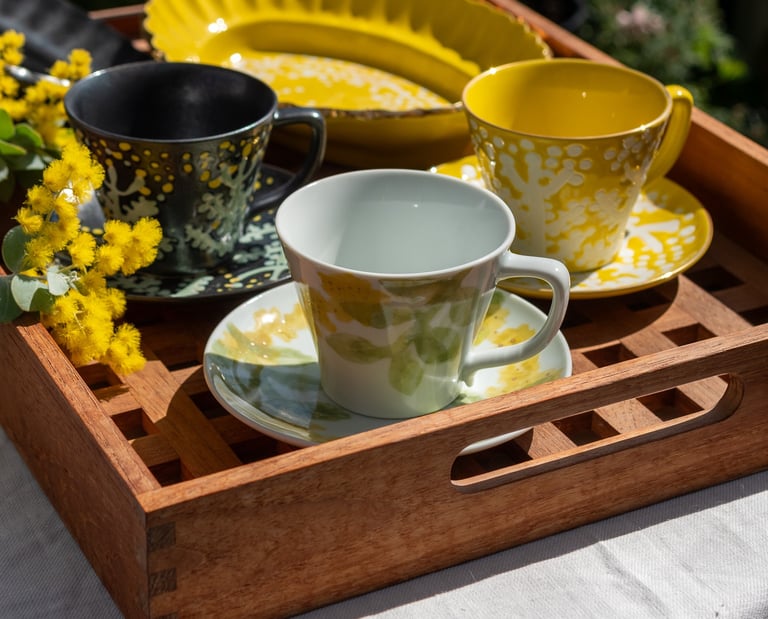 a tray with a tray of tea cups and a tray with a cup of coffee