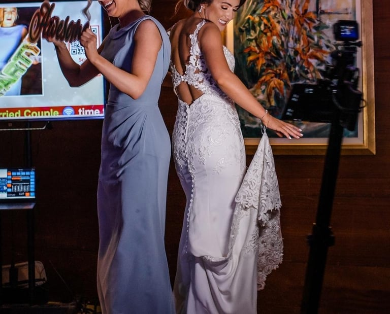 Bride and Maid of Honor standing on a 360 video booth
