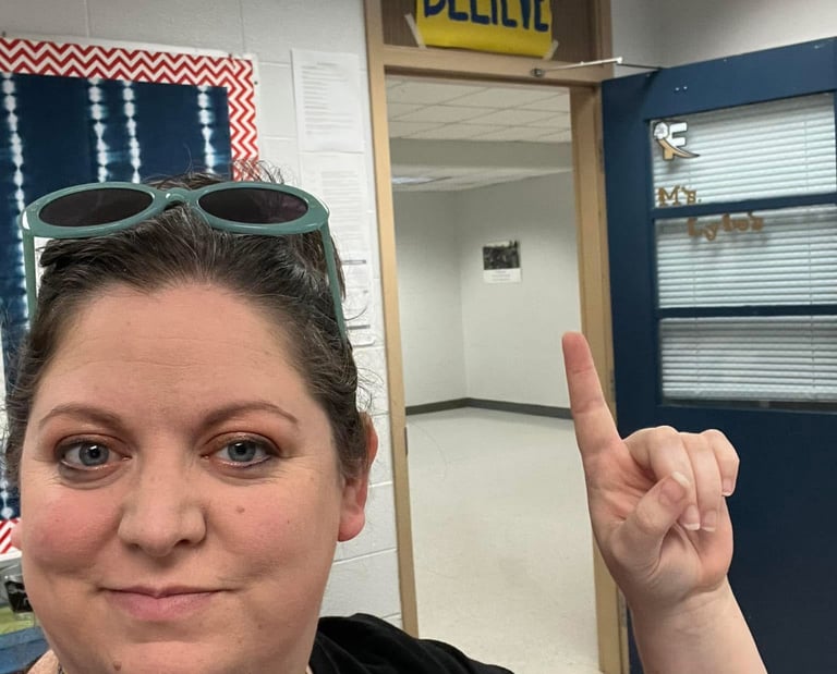 Woman with sunglasses standing in a classroom