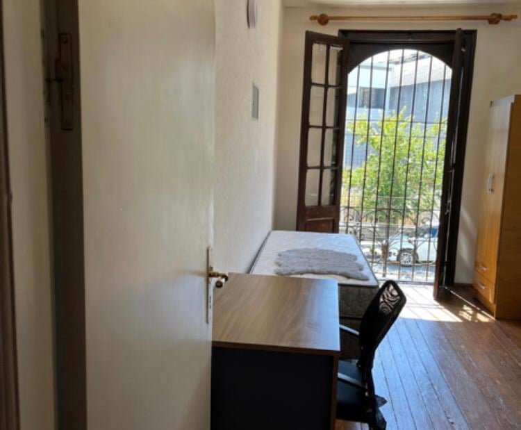 Habitación con escritorio mesa de luz y ventana
