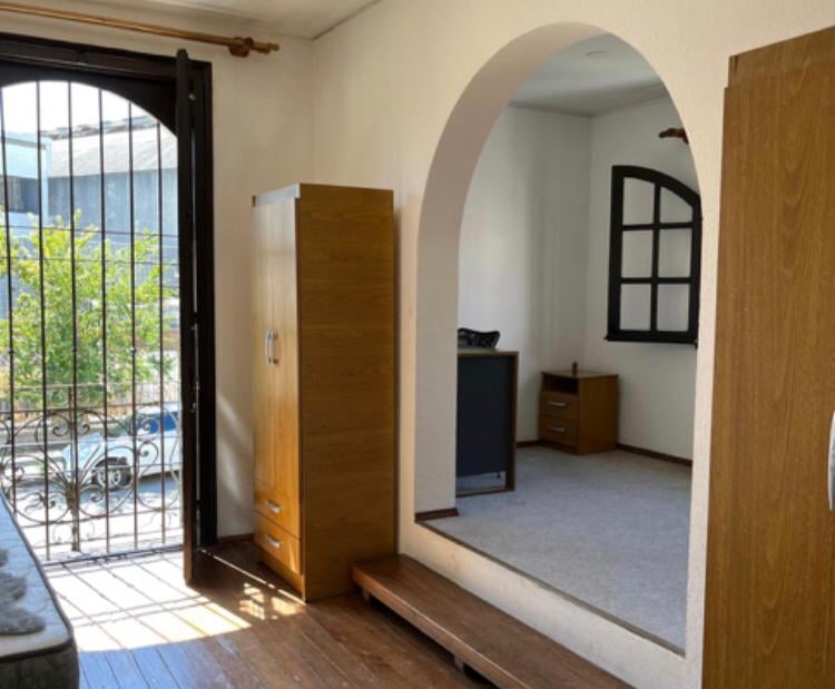 Habitación con escritorio mesa de luz y ventana