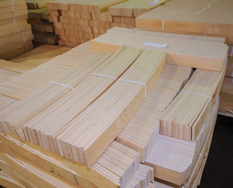 Bundled stacks of light-colored natural wood birch and beech bed slats in  warehouse.