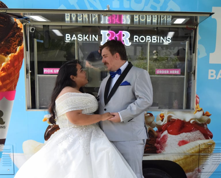 Wedding couple in a dress and gray tuxedo holding hands and looking at each other while enjoying BR 