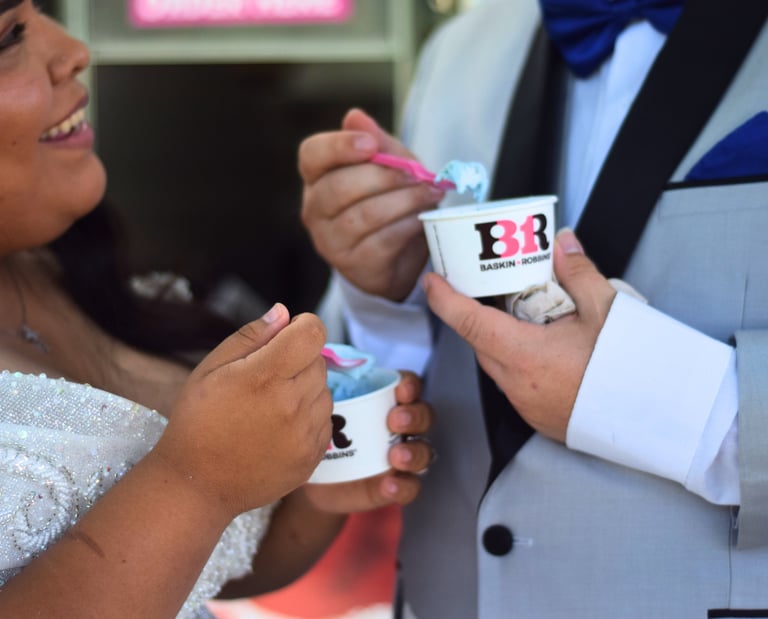 Close-up of smiling bride with groom holding ice cream during a Southern California wedding.