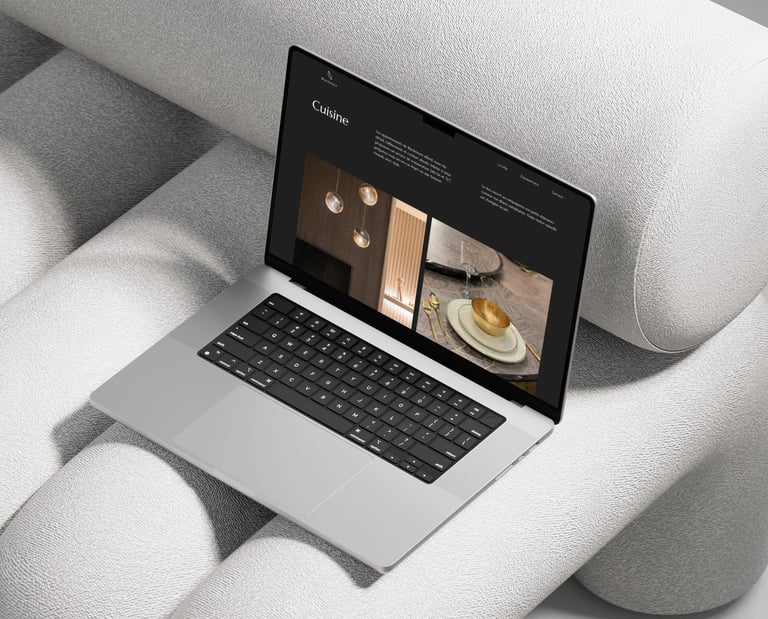 A silver laptop displaying a modern web design layout on a textured grey sofa.