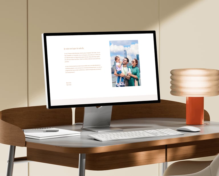 A desktop monitor displaying a professional website on a modern wooden desk with a stylish lamp.
