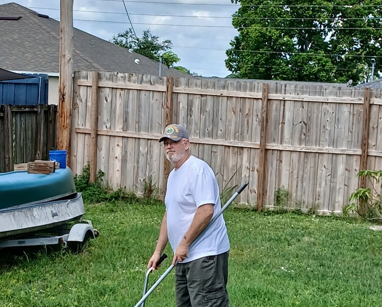 Robert using a sanitized scooper to remove waste from a customers back yard