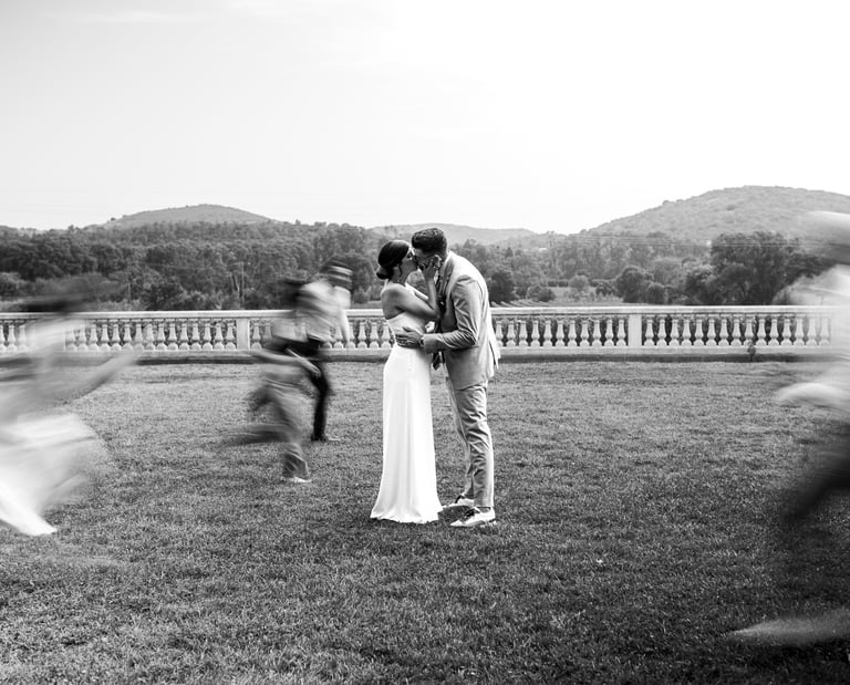 photo d'un couple qui s'embrasse et de leurs amis qui courrent
