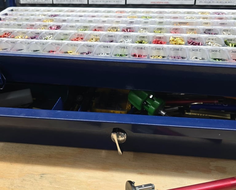 Close-up of lock rekeying pins and tools on a workbench