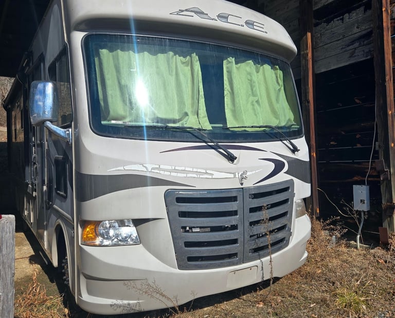 Rv parked outdoors beside a building