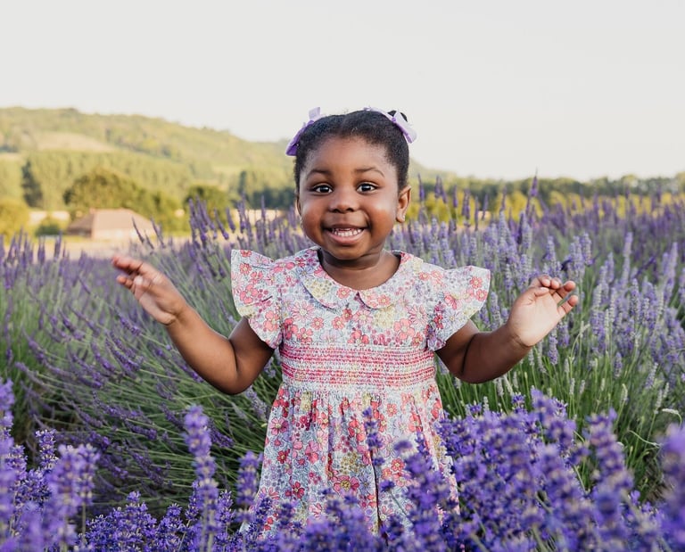 a little girl standing in a field of lavender flowers in Kent, UK