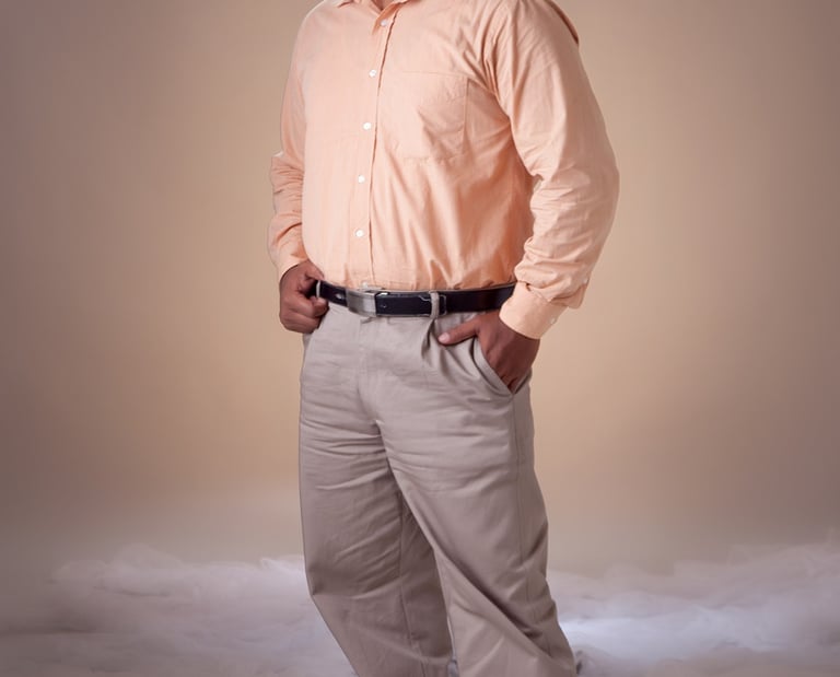 a man in a pink shirt and tan pants