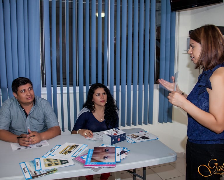 a woman standing in front of a table with a man in a blue shirt