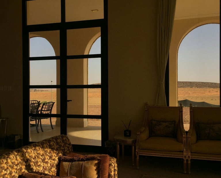 Warm sunlit living room with arched windows and classic lounge seating