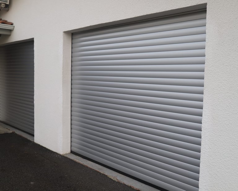 Porte de garage enroulante grise aluminium installé sur maison moderne par LB Menuiserie