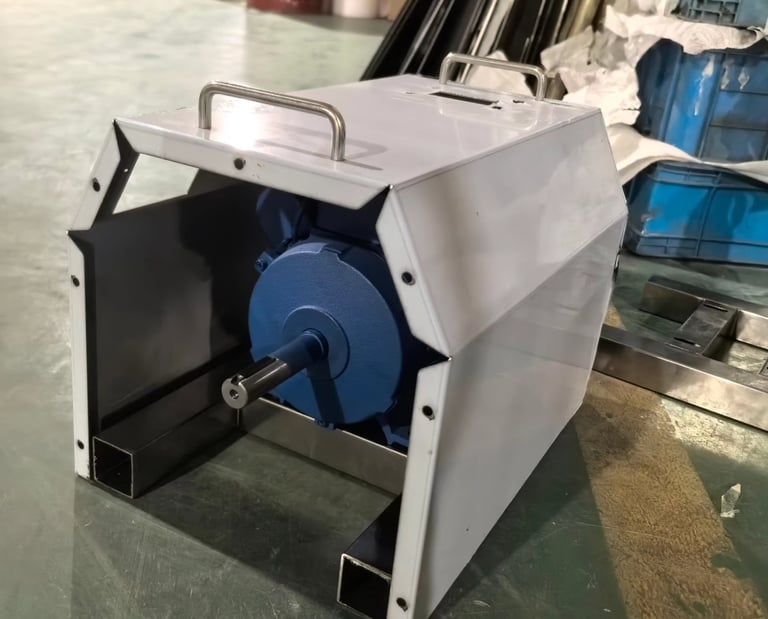 Industrial electric motor with a blue housing and metal protective cover in a factory warehouse.