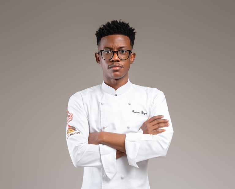 a male chef in a white uniform and glasses