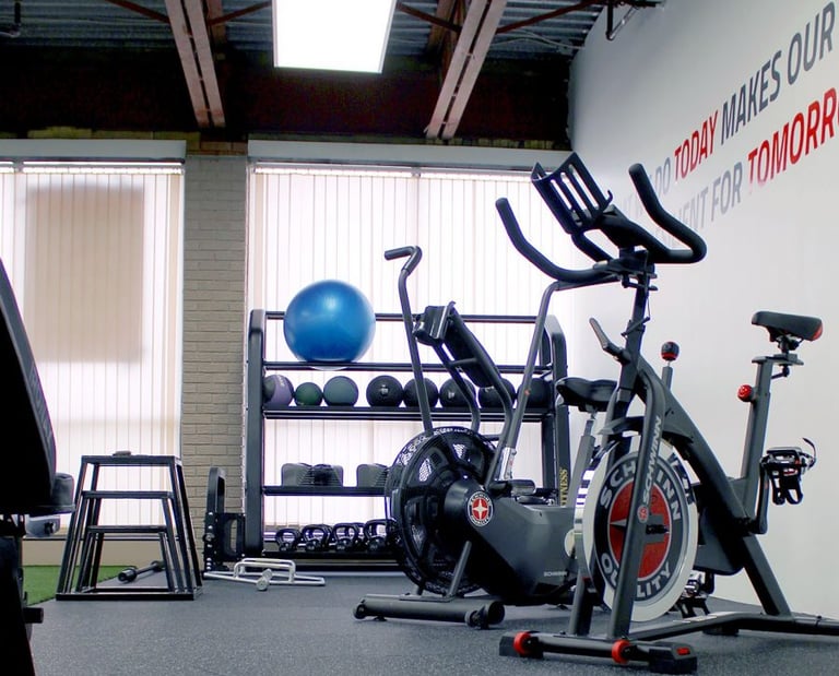 Modern home gym with air bikes, kettlebells, and fitness equipment for strength training.