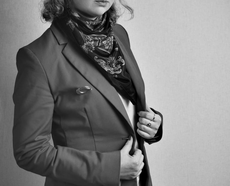 a woman in a suit and scarf with a scarf around her neck