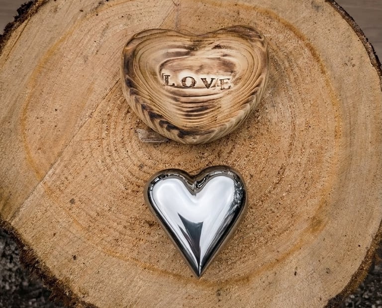 Polished metal love heart with scorched wooden heart-shaped holder with the word LOVE stamped on it