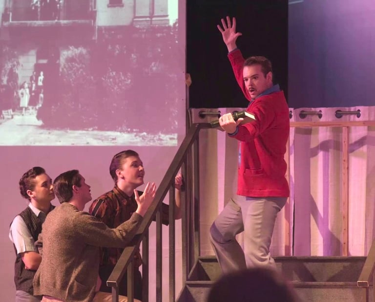 A handsome young man stands in frozen animation on the stairs.