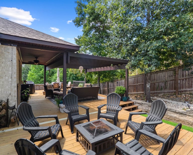 a patio with a fire pit and chairs