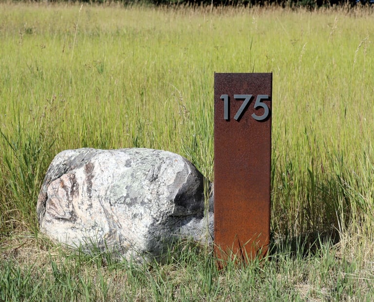 a stone and steel address marker