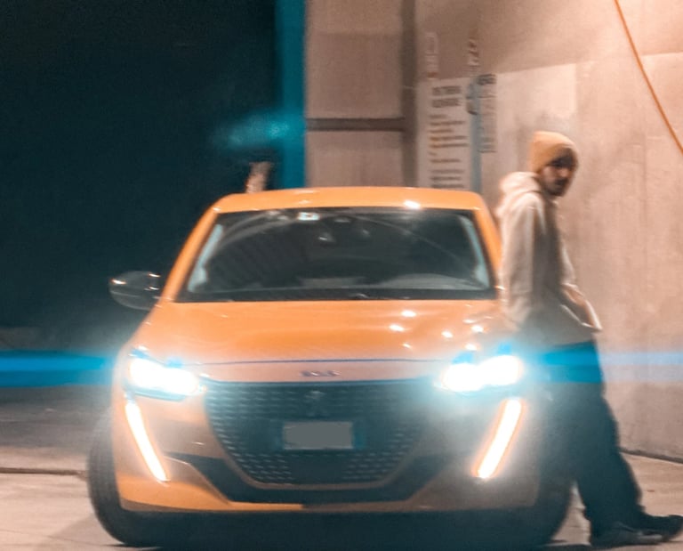 a man standing in front of a car with a light on it