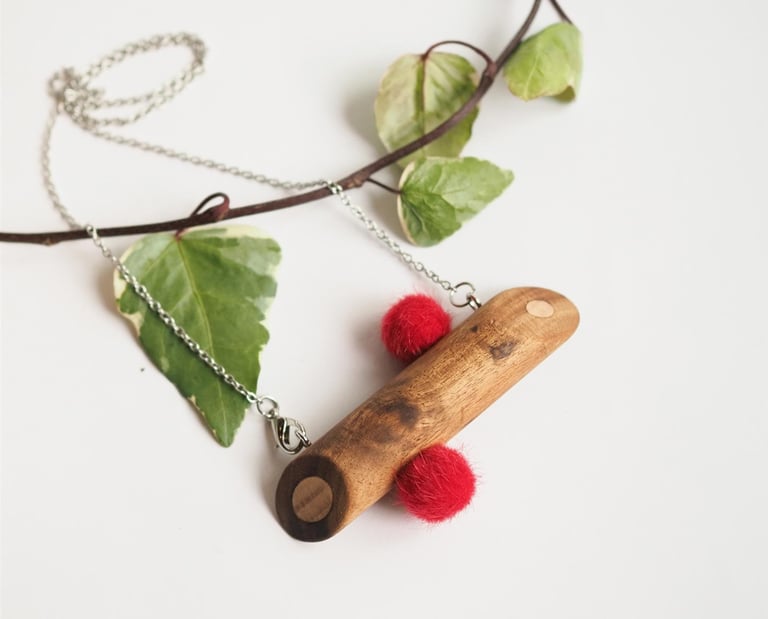 Necklace with wooden pendant and fluffy pompoms