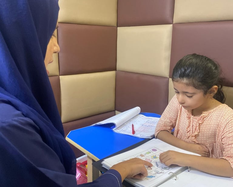 Therapist guiding young girl during session