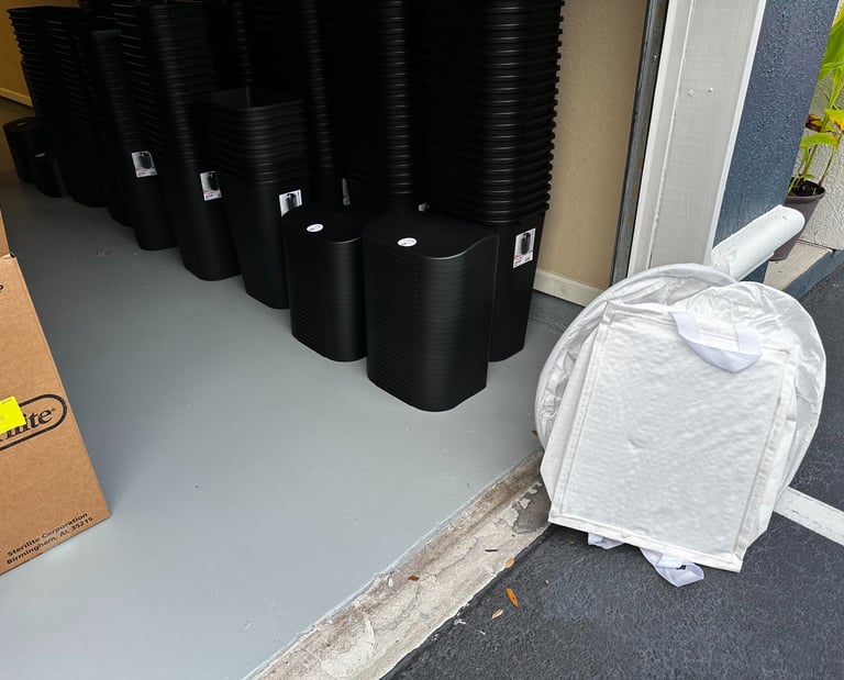 black trash cans stacked in a garage