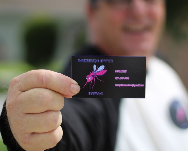 Mosquito Man owner holding company business card, locally owned mosquito control service