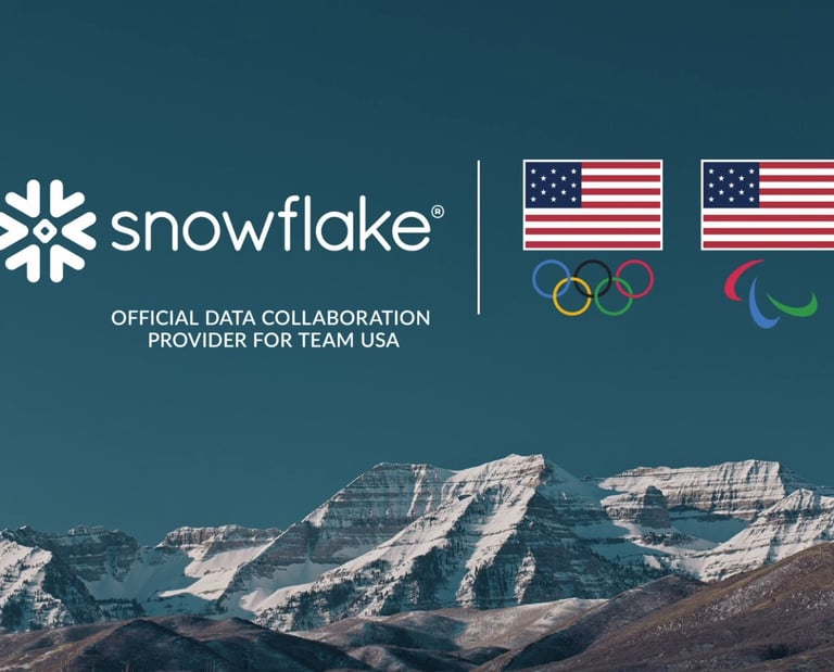 Snowflake logo and Team USA Olympic and Paralympic symbols over snowy mountain peaks.