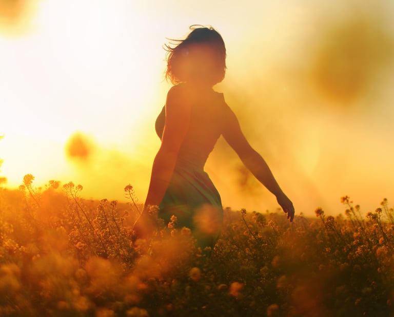a woman walking through a field of flowers