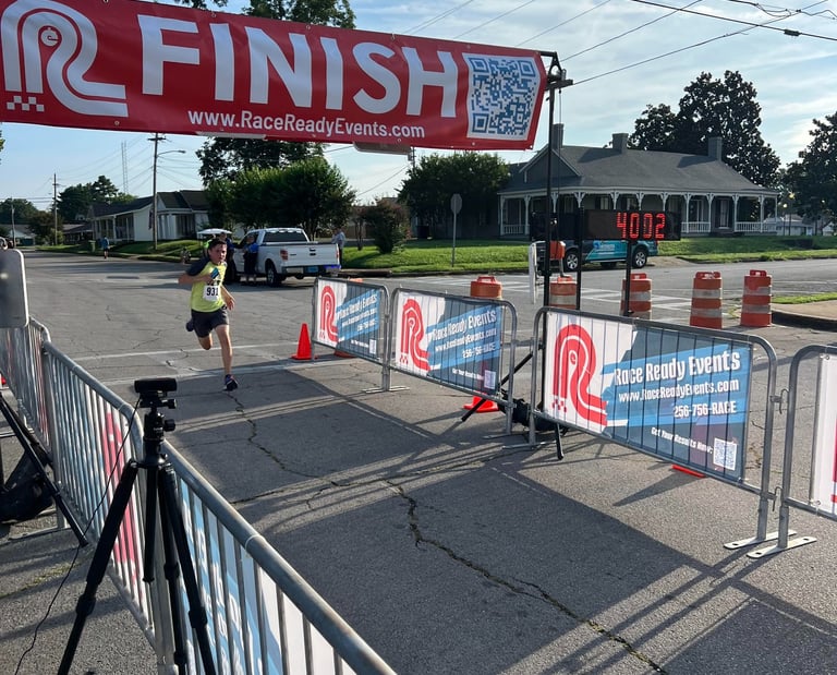 A young runner races through the finish line of a 5 Mile race in only 40 minutes, 2 seconds