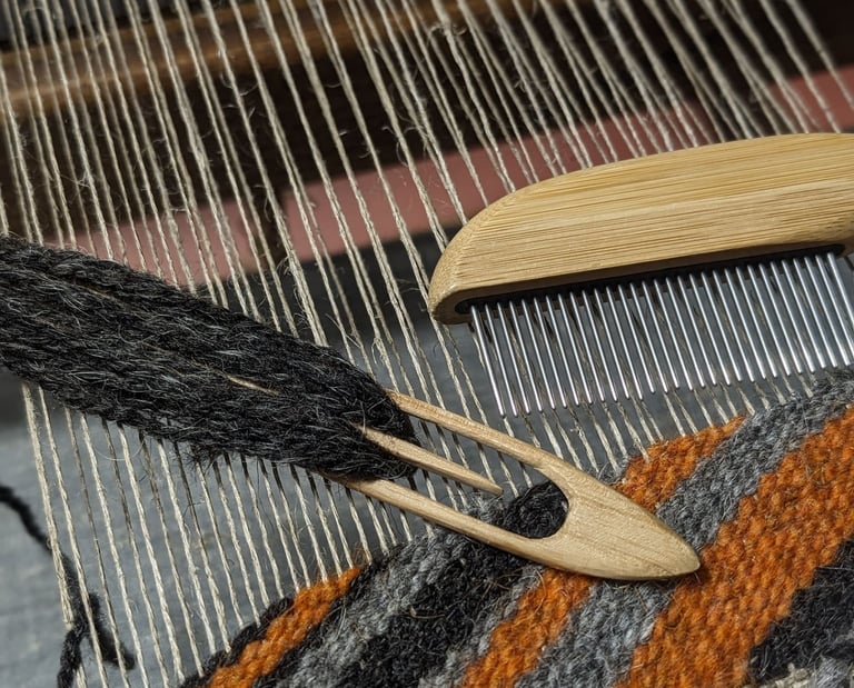a weaving loom with shuttle, combe and black grey orange wool diagonal threads on a navajo rug in pr