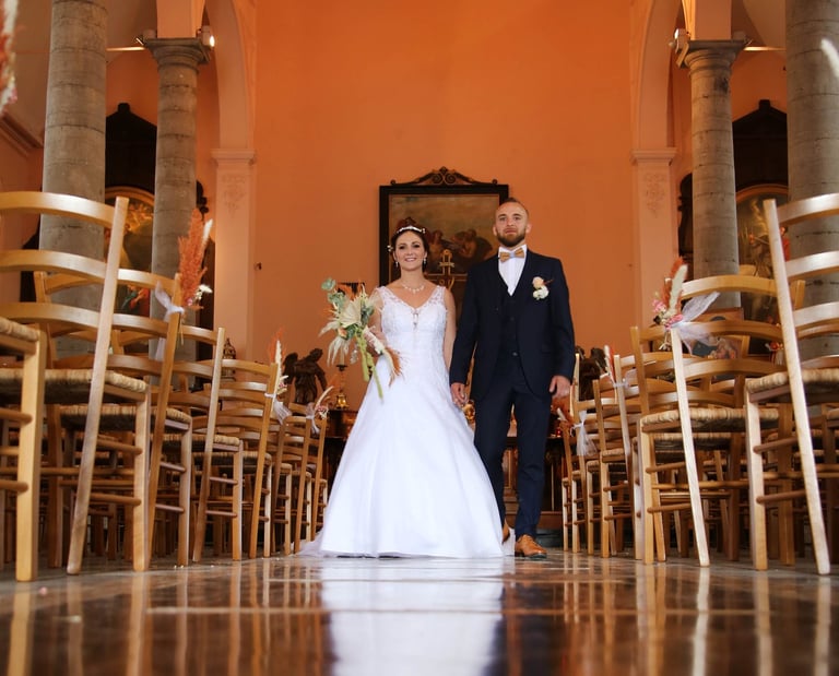 a bride and groom walking down the aisle of a church