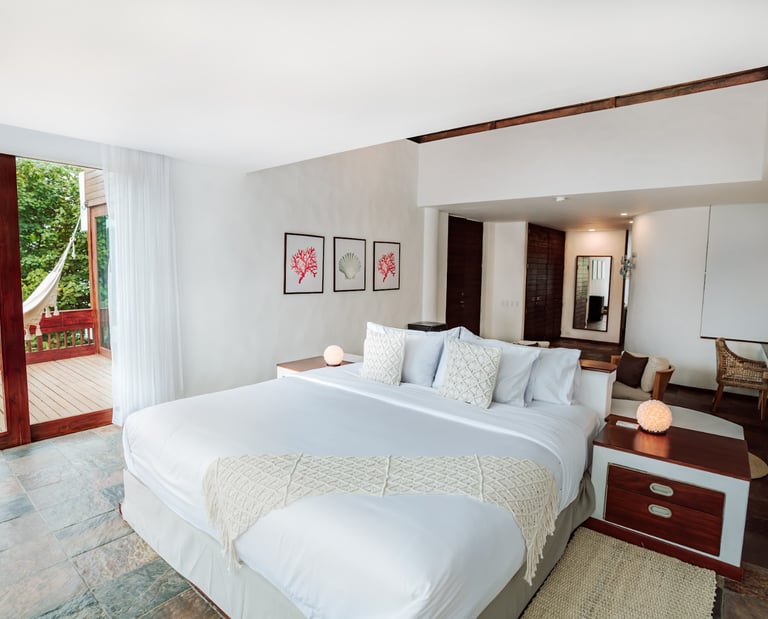Oceanfront bedroom at Villa Escalesia in Puerto Ayora, featuring direct access to a private wooden t