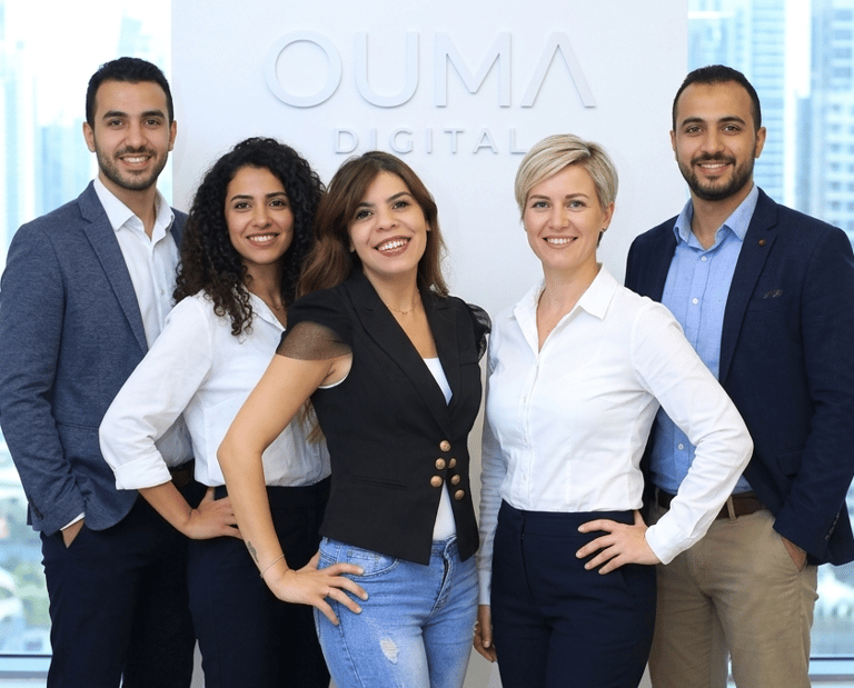 Professional Ouma Digital marketing agency team posing in a modern office.