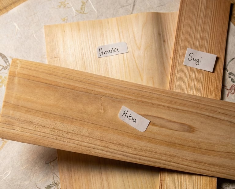 Samples of Hinoki, Hiba, and Sugi Japanese wood planks with natural wood grain on a tatami mat.