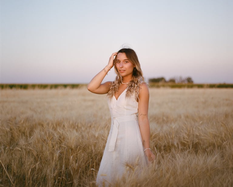 Une marié prend la pose dans un champ de blé. Photo prise à l'argentique avec la portra 400