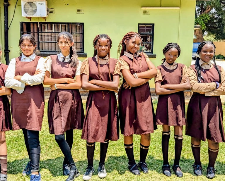 a group of girls in school uniforms standing in front of a building